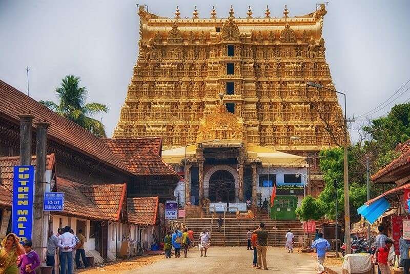 Visitors approaching a gold-colored temple tower