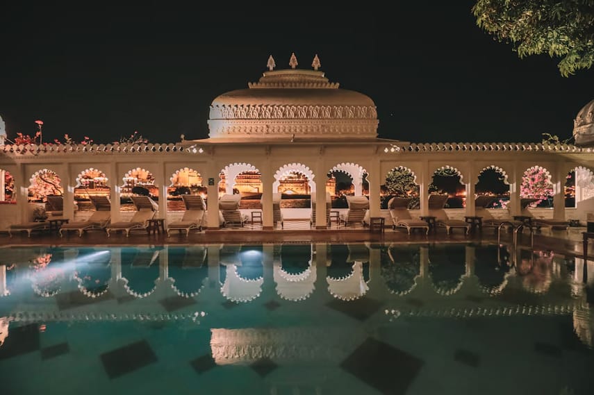 Arched hotel galleries reflected in a swimming pool at night