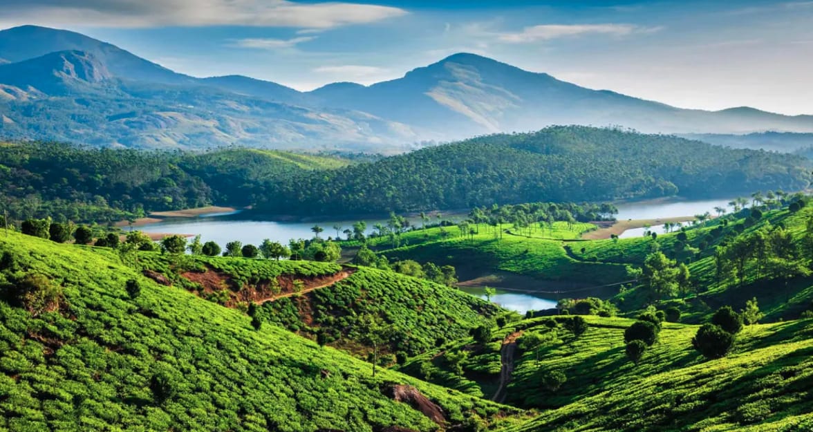 A green agricultural valley and lake below distant hills