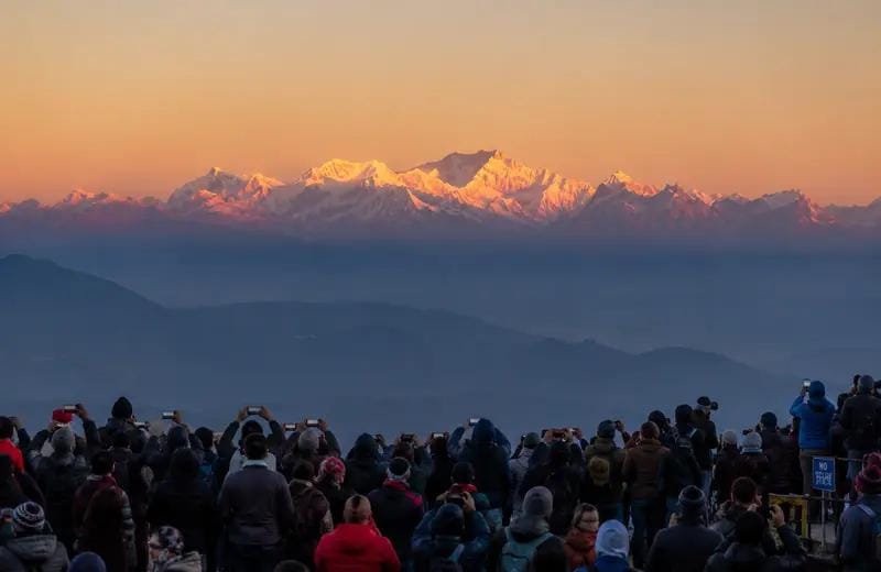 Visitors watching sunlight reach distant Himalayan peaks