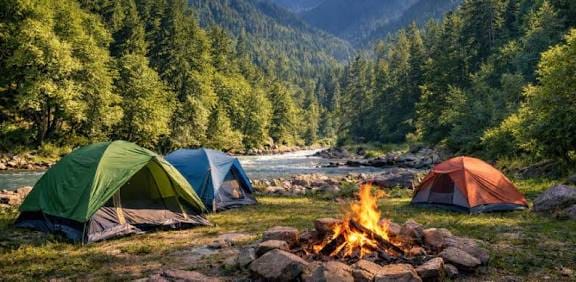 Tents and a campfire beside a rocky riverbank
