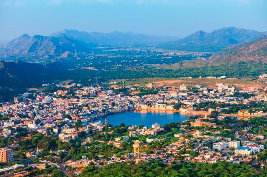 A town surrounding a lake beneath rocky hills