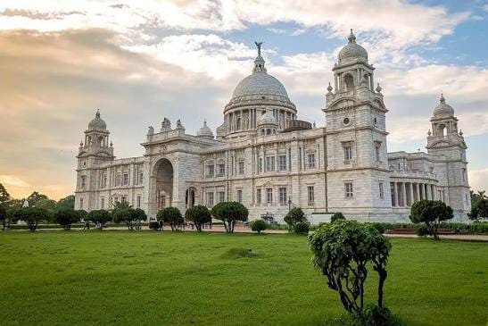 The white domes and towers of Kolkata's Victoria Memorial above a green lawn