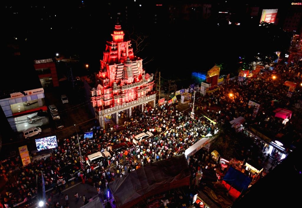 A crowd gathered beneath an illuminated festival structure