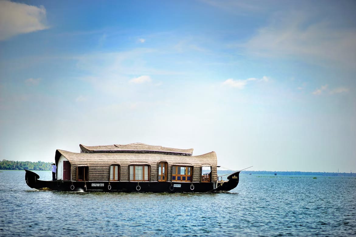A covered houseboat cruising across calm open water