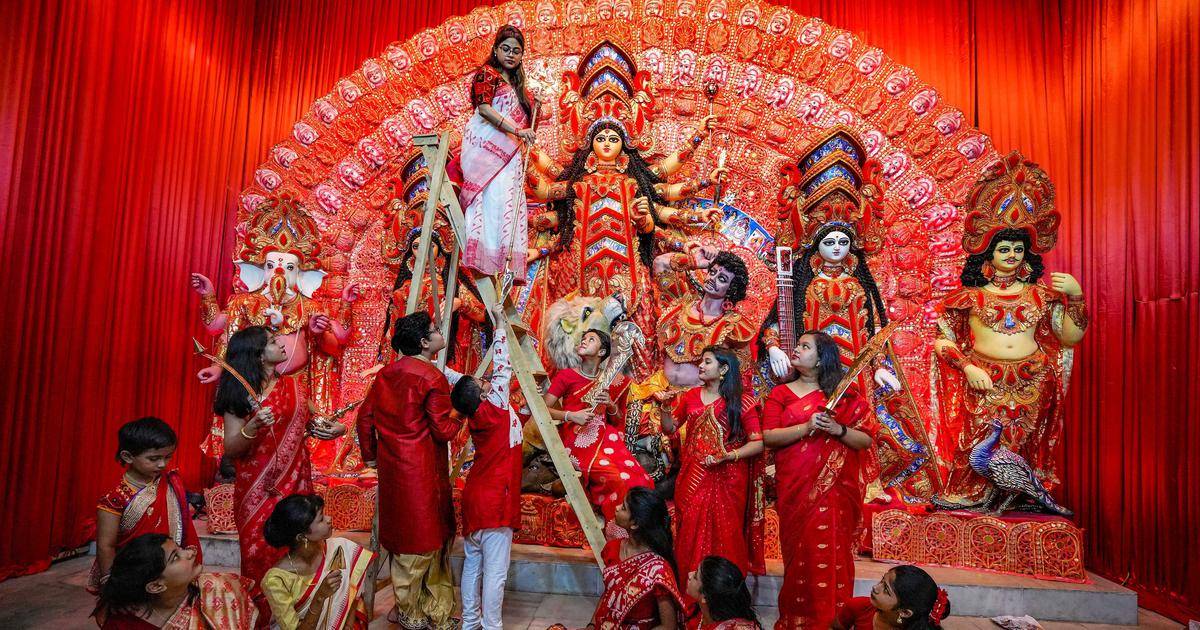 A colorful Durga idol display surrounded by other figures